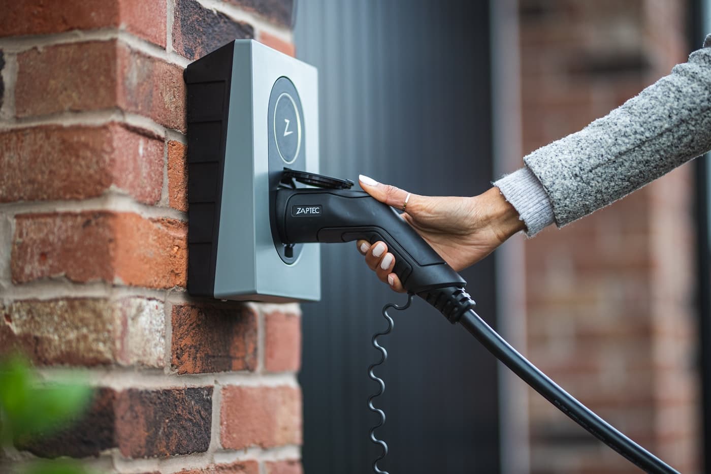 Eine Person lädt ihr E-Auto an einer privaten Wallbox zuhause